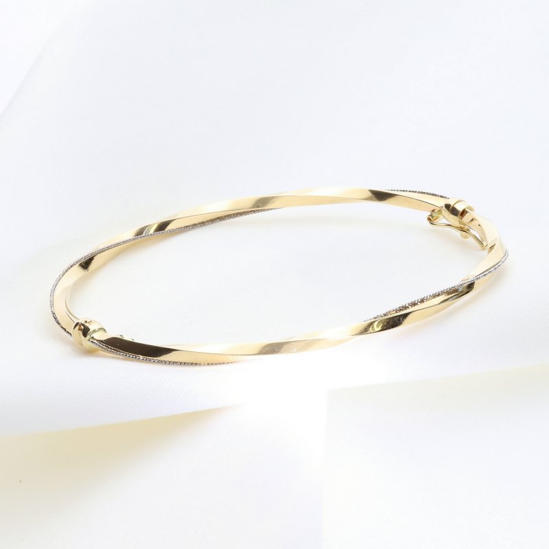 Złota bransoleta sztywna z efektem skręcenia i diamentowaniem