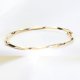 Złota bransoleta sztywna z efektem skręcenia i diamentowaniem